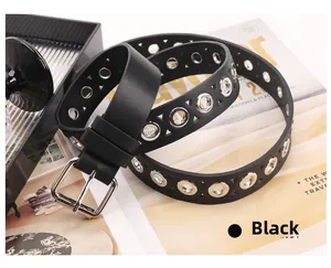 Detail of black punk leather belt featuring metal eyelets and a silver pin buckle