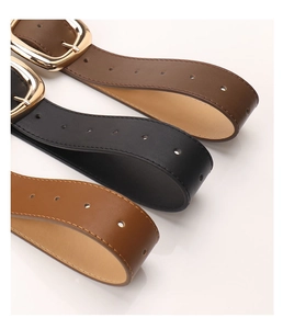 Three minimalist leather belts in brown, black and tan with polished gold metal buckles