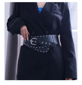 Détail d'une large ceinture noire punk Y2K avec des rivets argentés et boucle en métal