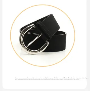 Detail of a wide black PU leather belt with matte texture and large silver D-ring buckle