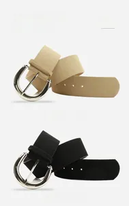 Detail of khaki and black suede belts with polished silver horseshoe buckles for women