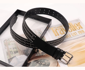 Détail de ceinture punk en cuir noir avec rivets argentés et boucle à double ardillon