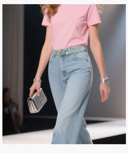Dettaglio della cintura in pelle azzurra con fibbia dorata su jeans in denim chiaro