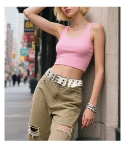 Detail of white punk belt with double row metal eyelets and silver buckle on model