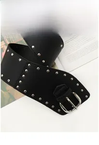 Détail d'une large ceinture noire en cuir de style Y2K punk avec des rivets argentés