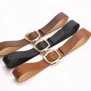Three minimalist women's wide leather belts in black and brown with large gold metal buckles