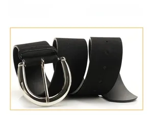 Detail of black faux leather wide belt featuring a large silver U-shaped alloy buckle