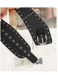 Gros plan d'une large ceinture noire punk Y2K ornée de clous argentés et boucle