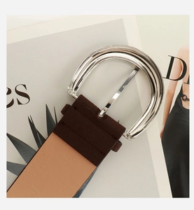 Close-up of vintage brown suede leather belt with large polished silver D-ring buckle
