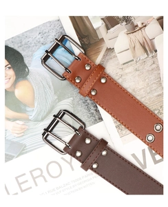 Detail of vintage brown and coffee leather belts with double grommets and metal buckles