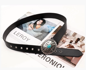 Western vintage black belt detail featuring engraved metal buckle with turquoise gemstone