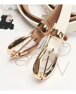 Détail de ceintures fines en cuir crème et camel avec boucles dorées polies