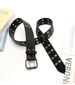 Detailed view of black punk belt with silver double grommets and sturdy two-prong metal buckle