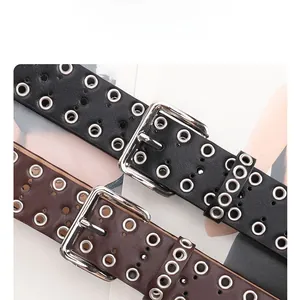 Detail of punk style multi-eyelet belts in black and brown with silver alloy buckles