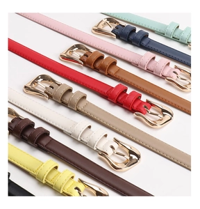 Detail of colorful slim PU leather belts with polished gold buckles in a diagonal layout
