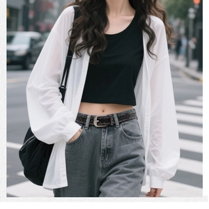 Urban chic street style with white sheer cardigan, black crop top, and denim jeans with belt
