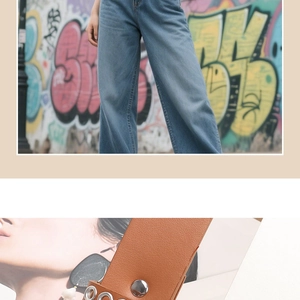 Close-up of brown litchi grain leather belt with silver eyelets and metal snap buttons