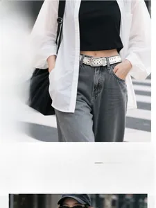 White faux leather belt with star hollow design and silver buckle on denim jeans