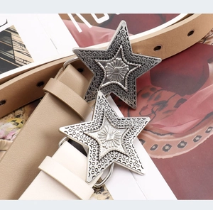 Detail of star-shaped metal buckle on punk style faux leather belts with embossed patterns