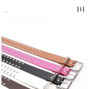 Close-up of punk style belts with double metal eyelets and polished square buckles