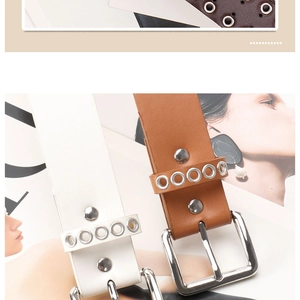 Close-up of brown and white punk eyelet belts with silver buckles on fashion magazine