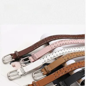 Detail showing five colors of leather belts with star-shaped cutouts and metal studs