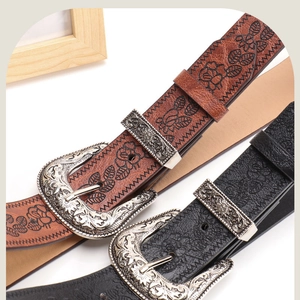 Detailed macro of vintage embossed leather belts with floral patterns and silver buckles