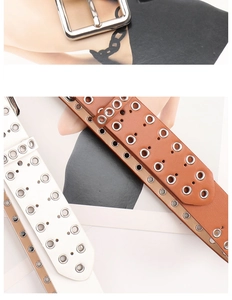 Close-up of punk style leather belts with silver metal eyelets and square pin buckle