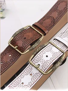 Detailed close-up of vintage embossed leather belts with antique bronze buckles
