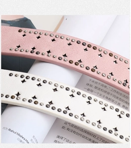 Detail of pink and white faux leather belts with metal studs and star cutouts