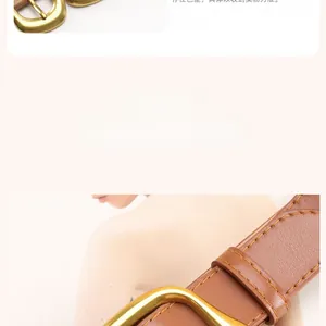 Detail of brown leather belt with smooth gold buckle and yellow stitching for women