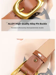 Detail of a brown leather belt featuring a matte gold alloy square buckle with stitching