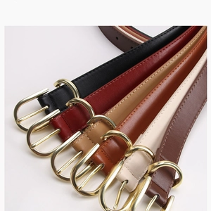 Detailed view of assorted thin leather belts with elegant golden round metal buckles