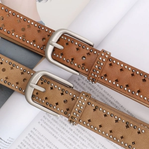 Women's brown leather belt with silver buckle, metal studs, and star cutouts for jeans
