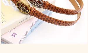 Close-up of brown leather belt featuring quilted texture and vintage oval metal buckle