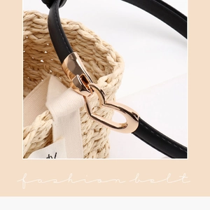 Gros plan sur une fine ceinture en cuir noir dotée d'une boucle coeur en alliage doré