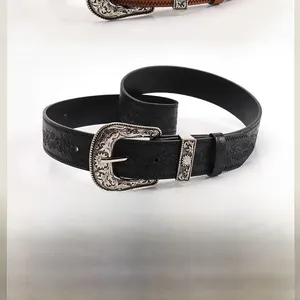 Close-up of embossed patterns and vintage metal buckles on camel and black belts