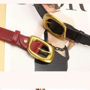 Detail of burgundy and black leather belts featuring irregular gold square buckles