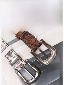 Détail de ceintures en cuir vintage avec gaufrage papillon et boucle en métal argenté