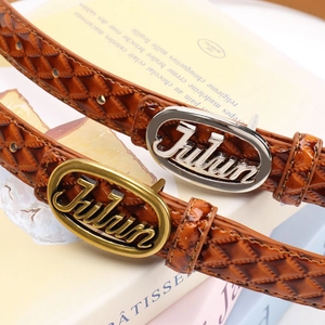 Brown leather belt with quilted pattern and oval metal buckle on vintage book