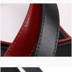 Detailed macro view of high-quality leather belt strap with contrast red and black stitching