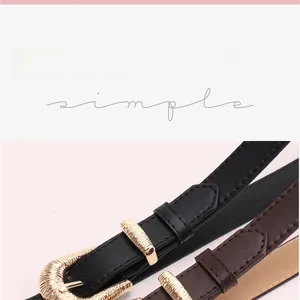 Close-up of thin leather belts with shell-textured gold buckles in black and brown