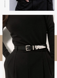 Close-up of black western belt with vintage silver engraved metal buckle and tip detail