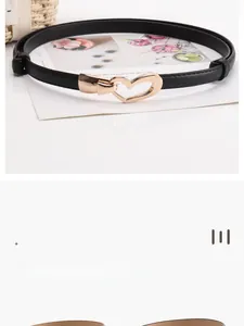 Détail de la ceinture en cuir noir texturé avec une boucle dorée en forme de cœur