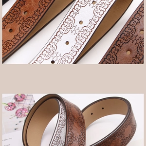 Detail of vintage embossed leather belts with folk patterns and bronze buckles for jeans