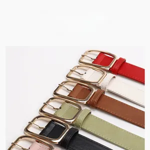 Close-up showing various colors of thin leather belts with gold metal buckles for women
