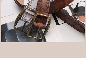 Detail of vintage embossed leather belt with antique bronze buckle and ethnic floral pattern