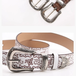 Détail de la ceinture en cuir avec motif papillon et boucle métallique de style western