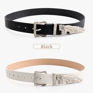 Detail of vintage carved metal buckle and tip on black and off-white leather belts