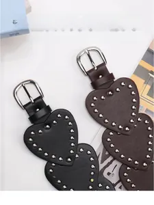 Detail of vintage Y2K belt featuring heart-shaped leather patchwork and silver metal rivets